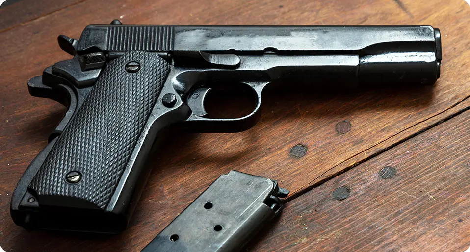 Handgun and clip on a wooden table