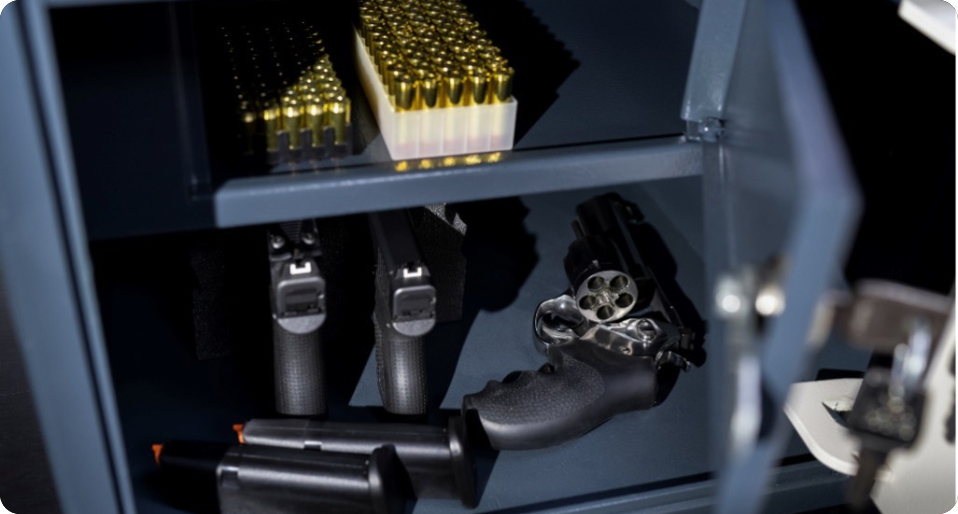 Open gun safe showing multiple guns and ammunition 
